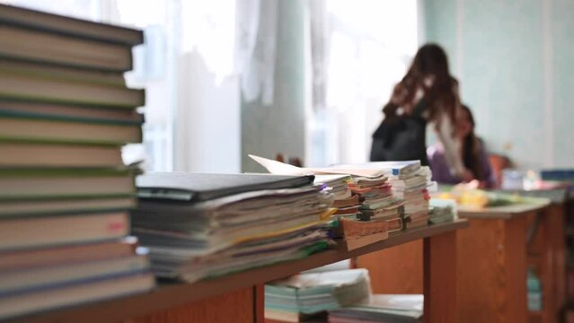 Stacks of books and notebooks in the school's teacher's lounge.