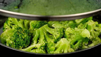 Fresh green broccoli frying on a pan. Healthy food, vegetarian cuisine