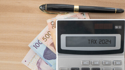 Tax 2024. Word Tax 2024 on calculator. The new year 2024 tax concept.Income tax return.