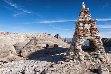 Dolomites, Italian Alps. The mound on the stone in the foreground and the rifugio Boe hut in the...