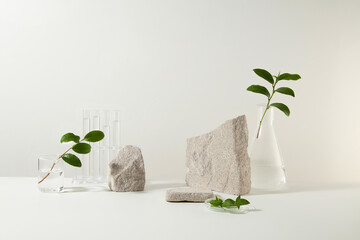 Gray blocks of stone decorated with lab equipments containing green tea leaves on white background....