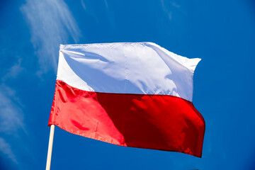 Polish flag against a blue sky background