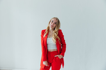 Portrait of a beautiful young blonde woman in a red business suit