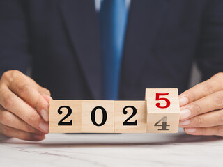 Flipping of 2024 to 2025 on wooden cubes for preparation of new year change.