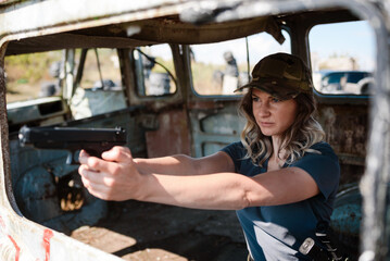 A girl with a pistol in her hand learns to shoot at the shooting range