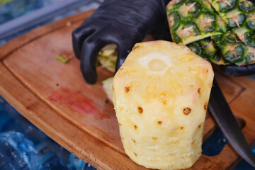  cutting pineapple on a chopping board 