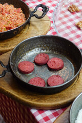  salami sausage in pan served with cheese on table 