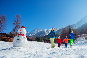 Family with kids enjoys scenic Alpine walk in winter resort