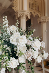 Bouquet of white roses in classic interior. Luxurious arrangement of roses at wedding ceremony. 