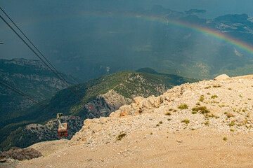 A rainbow on the side of a mountain. lift