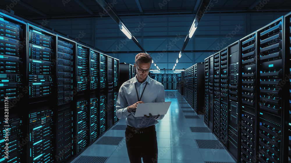 Poster futuristic concept: big data center chief technology officer holding laptop, standing in warehouse, 
