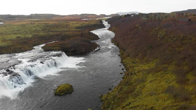 Faxi waterfall and flowing river stream in nordic heath landscape.