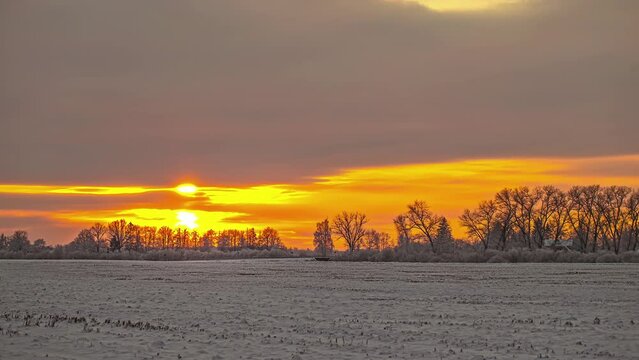 Time lapse of yellow orange sunset in the winter wonderland rural area