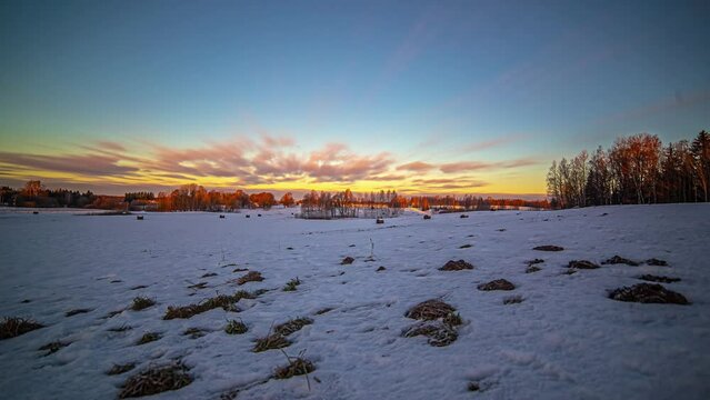 Timelapse shot of white clouds passing over snow covered farmlands on a cold winter day.