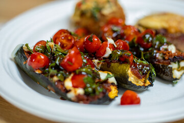 Delicious and healthy food. Grilled eggplants stuffed with cherry tomatoes, herbs and cheese .