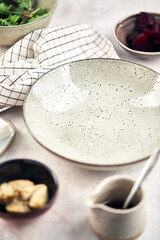 Empty plate and ingredients for preparing salad with beets and artichokes