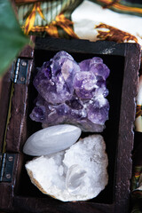 amethyst geode in a wooden box with quartz and selenite with incense stick