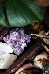 amethyst geode in a wooden box with quartz and selenite with incense stick