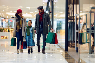 Happy family enjoys in Christmas shopping at the mall.