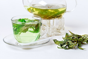 Herbal organic Chamaenerion tea in glasspot and teacup isolated on white background. Side View....