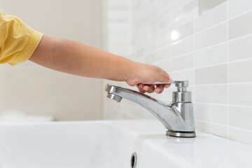 Save water. Little kid keeps turning off the running water in the bathroom to protect environment. Greening planet, reduce global warming, Save world, life, future, risk energy, crisis , water day.