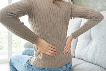 woman holding her lower back while and suffer from unbearable pain health and problems, chronic back pain, backache in office syndrome, scoliosis, herniated disc, muscle inflammation