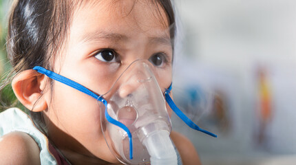 Kid girl making makes inhalation nebulizer steam sick cough at home, Asian Child using nebulizer...