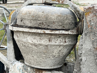 Cement mixer machine at construction site, tools and sand