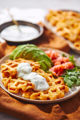 Hearty sweet potato or pumpkin waffles with avocado, salmon, arugula and sauce