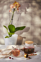 Fruits and berries tea. Glass teapot and cup on the table
