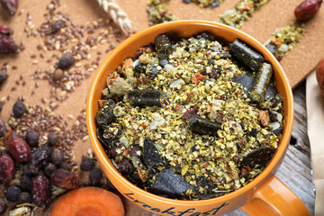 special muesli and granules for senior horses  served in bowl around muesli background.  feeding and horse care concept. close up