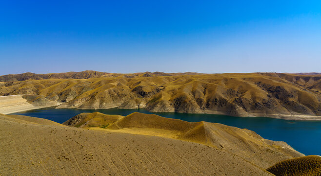 A deserted part of the Zaamin nature reserve in Uzbukistan on a sunny summer day. View of the mountains and reservoir.
