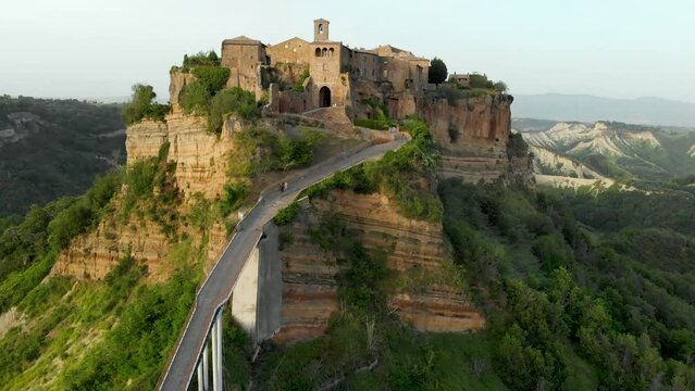 Aerial summer evening view of famous Civita di Bagnoregio town, beautiful place located on top of a volcanic tuff hill overlooking the Tiber river valley. The place has Etruscan and Medieval origins.