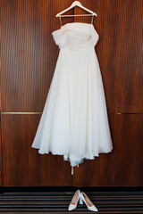 Classic white wedding dress and shoes on the wall. 