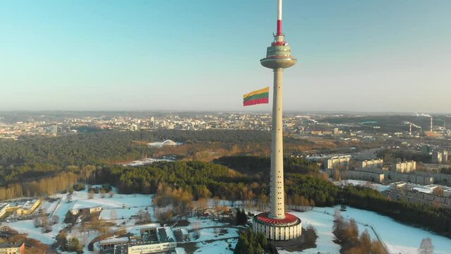 Giant tricolor Lithuanian flag waving on Vilnius television tower on the celebration of Restoration of the State Day in Vilnius. Aerial view.