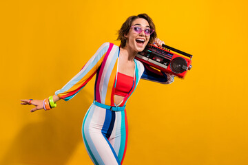 Photo of excited girl in retro costume listen boom box enjoy occasions isolated vivid color background