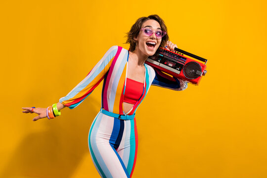 Photo of excited girl in retro costume listen boom box enjoy occasions isolated vivid color background