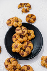 crumbly cookies with chocolate on black plate