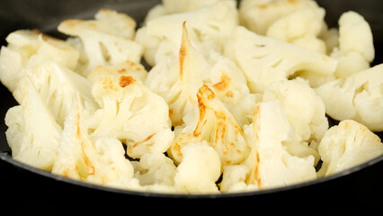 Fresh cauliflower frying in pan