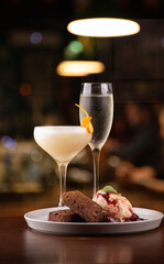 pairing sweet ice cream dessert with brownie and porn star martini cocktails and glass of dry sparkling wine blurred background