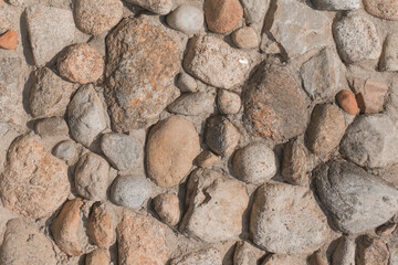 Stones cobblestones in cement wall solid texture background rough rock