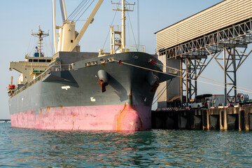 Big crane loading cargo container from truck to container ship in the international terminal...