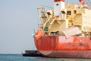 Fototapeta premium Watertight lifeboat test. Port state control. Lowering orange totally enclosed lifeboat to water. Abandon ship drill. Lifeboat training.