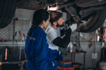 Fototapeta na wymiar Auto mechanics diagnose suspension issues using precise tools, ensuring safe vehicle performance.