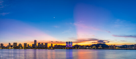 Beautiful coastline and modern building scenery at sunset by the sea, Zhuhai, Guangdong Province, China.