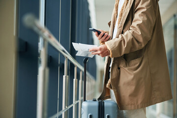 In casual jacket. Close up view of man with luggage, conception of airport travel