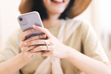 Closedup woman hand typing message with smartphone in quiet luxury beige fashion modern lifestyles