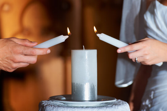Couple, hands and candle at wedding for love, unity and commitment at church or ceremony with closeup. Marriage, man and woman with light for trust, relationship and compromise with bride and groom