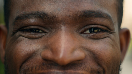 Cropped view close up male eyes African American smiling happy carefree man ethnic joyful male...