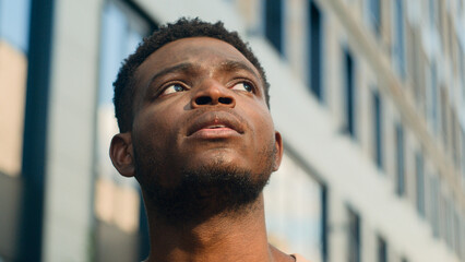 Close up pensive thinking ethnic man looking around outdoor business student guy look up on urban...